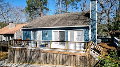 Rear view of property featuring a chimney, a deck,