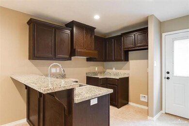 Kitchen featuring dark brown cabinetry, baseboards, light stone counters, recessed lighting, and a peninsula