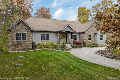 Ranch-style house featuring stone siding, a front yard, and a shingled roof