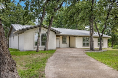 View of front facade featuring driveway, a metal r