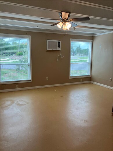 Empty room featuring a ceiling fan, a wall mounte