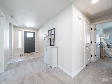 Entryway with light colored carpet and a textured ceiling