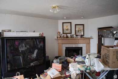 Living area featuring a tile fireplace and a textured ceiling