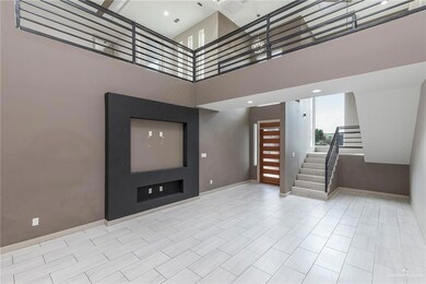 Unfurnished living room featuring stairs and a towering ceiling