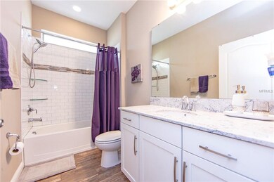 Shared hall bathroom features glass corner shelves
