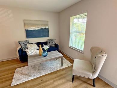 Sitting room with wood finished floors and basebo