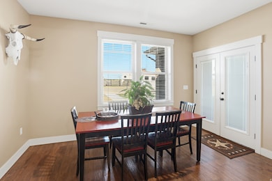 Dining room with french doors and dark wood-style floors