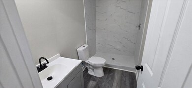 Full bath with vanity, toilet, a stall shower, and