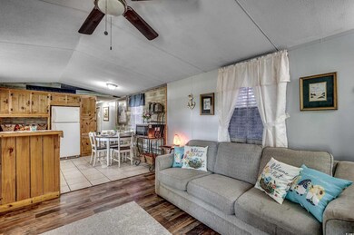 Living room featuring lofted ceiling, ceiling fan,