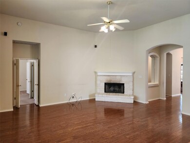 Unfurnished living room featuring ceiling fan, wo