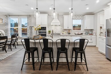 Chef's kitchen including built in double wall ovens, quartz, SS appliances, and ceramic tile backsplash.