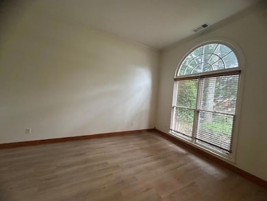 Unfurnished room with light wood finished floors, crown molding, and baseboards