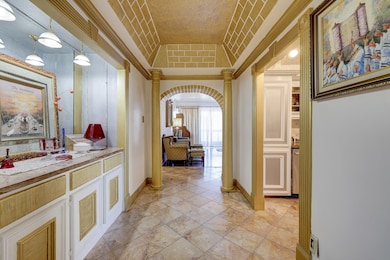 Step into an impressive formal entry with tile flooring, built-in cabinets, high ceiling ceiling, and a stylish accent mirror.