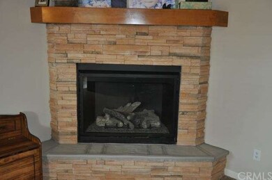 Gas fireplace with stone face and alder mantle. 