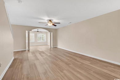 Empty room featuring ornate columns, ceiling fan, 