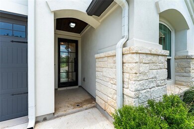 View of exterior entry with stone siding and stuc