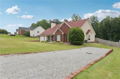 Traditional-style house with a garage, cooling unit, a chimney, brick siding, and driveway