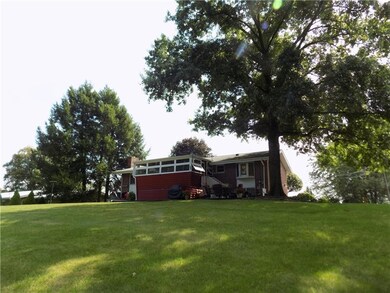 Rear view shows screened in porch and patio.