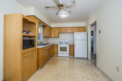 Kitchen with ceiling fan, sink, and white applianc