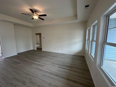 Spare room with baseboards, a raised ceiling, wood