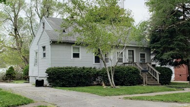 View of asphalt driveway and view of back yard.