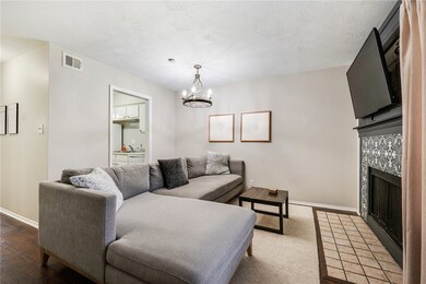 Living area with baseboards, a fireplace, a chande