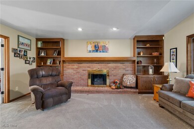 Living room with light carpet, a fireplace, recessed lighting, and built in shelves