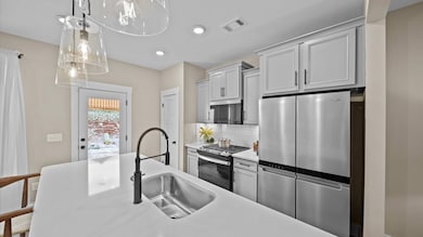 Kitchen with gray cabinetry and large island for counterstools