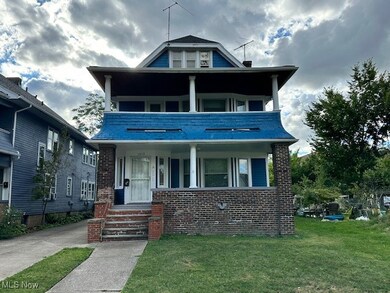 View of front of property featuring a balcony, covered porch, and a front lawn
