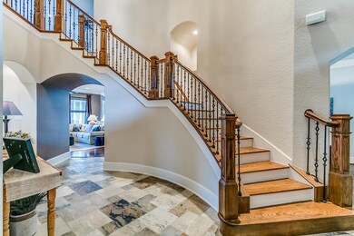 Through the double wood entry doors you ll find this stunning entry with slate tile floors, curved walls & wrought iron stairway.