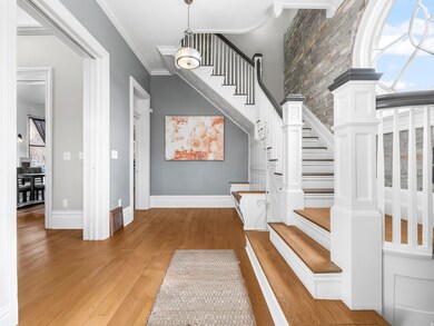 Staircase featuring wood finished floors and ornamental molding