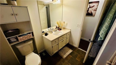 Bathroom with baseboards, toilet, and vanity