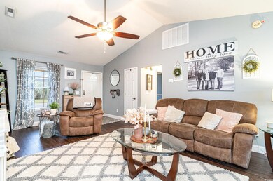 Living room featuring lofted ceiling, dark wood-ty