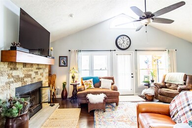 Living area with door to back porch. Fireplace and