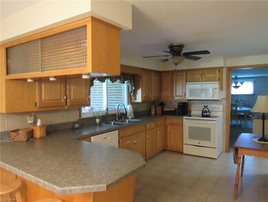 Kitchen with white appliances, tile floors, and br