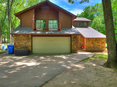 View of front of home featuring stone siding, a ga