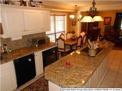 Kitchen has granite counter tops and top of the li