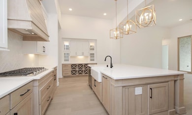 Kitchen with a chandelier, tasteful backsplash, c
