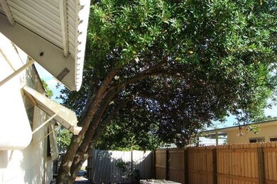 Fenced yard area to yellow home.