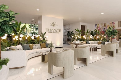 The lounge area in ELEVATE is designed with a contemporary and inviting atmosphere. Offering ample seating, complemented by several stylish armchairs arranged around a central coffee table. The space is adorned with numerous plants, adding a touch of nature and enhancing the ambiance.