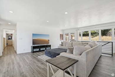 Living room featuring recessed lighting, wood finished floors, and plenty of natural light