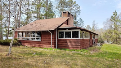 View of side of property featuring a chimney and a lawn
