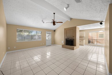 Family room opens to back yard. Breakfast room and kitchen can be seen. All Easy-care tile with neutral colors.