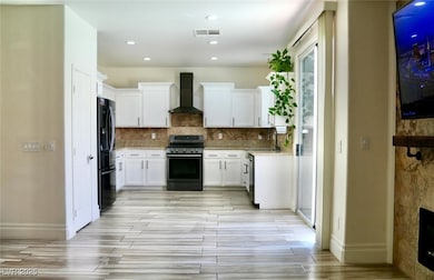 Kitchen with wall chimney exhaust hood, appliances