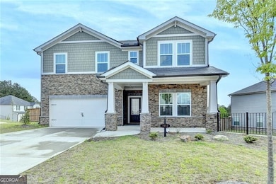 Craftsman house featuring stone siding, a front ya