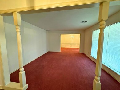 Carpeted empty room with an inviting chandelier
