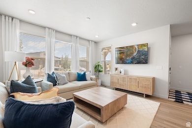 Living area featuring plenty of natural light, light wood finished floors, recessed lighting, and a textured ceiling