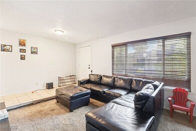 Living area featuring a textured ceiling and carpe