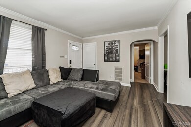 Living room featuring ornamental molding and hardw
