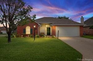 Single story home with a garage and a lawn